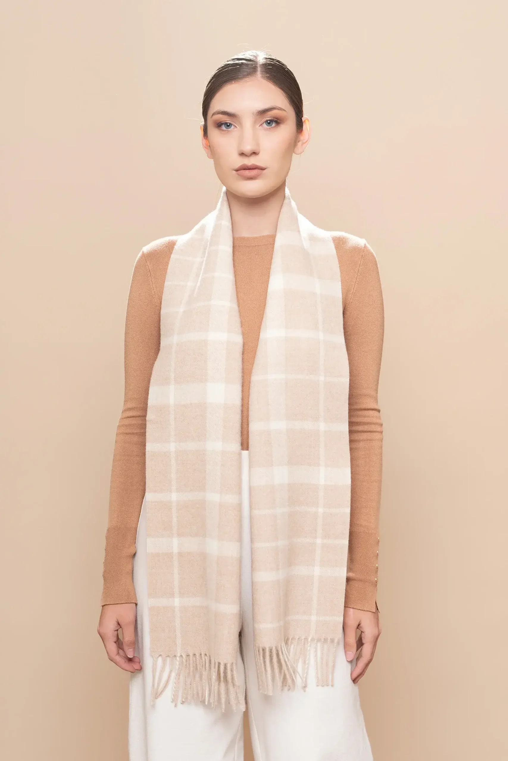 Mujer de frente con bufanda de baby alpaca a cuadros beige y blanco natural