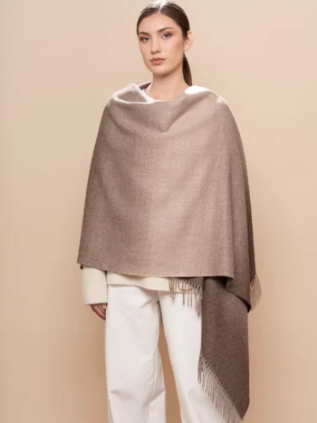 mujer con chal de baby alpaca, en el hombro, en canela y marrón natural
