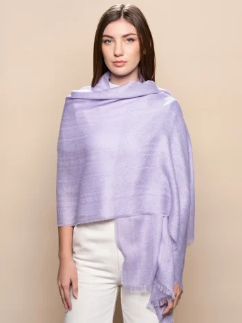 Mujer con chal en el hombro de baby alpaca en lavanda con tejido jacquard