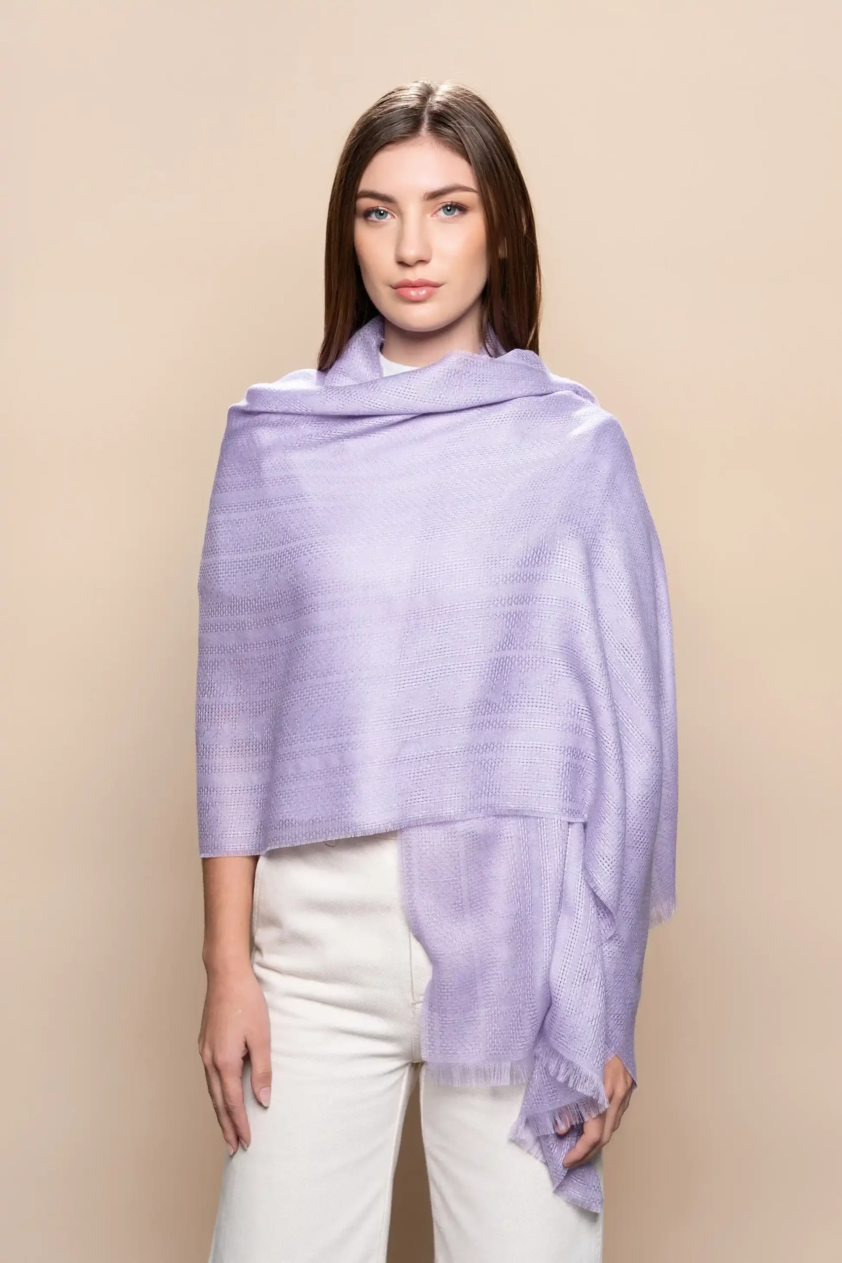Mujer con chal en el hombro de baby alpaca en lavanda con tejido jacquard